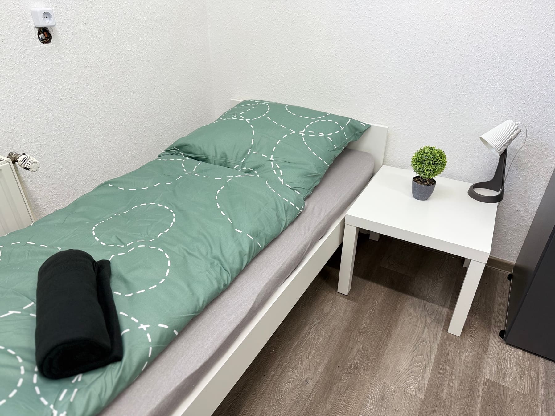 Schlafzimmer mit Einzelbett und Nachttisch