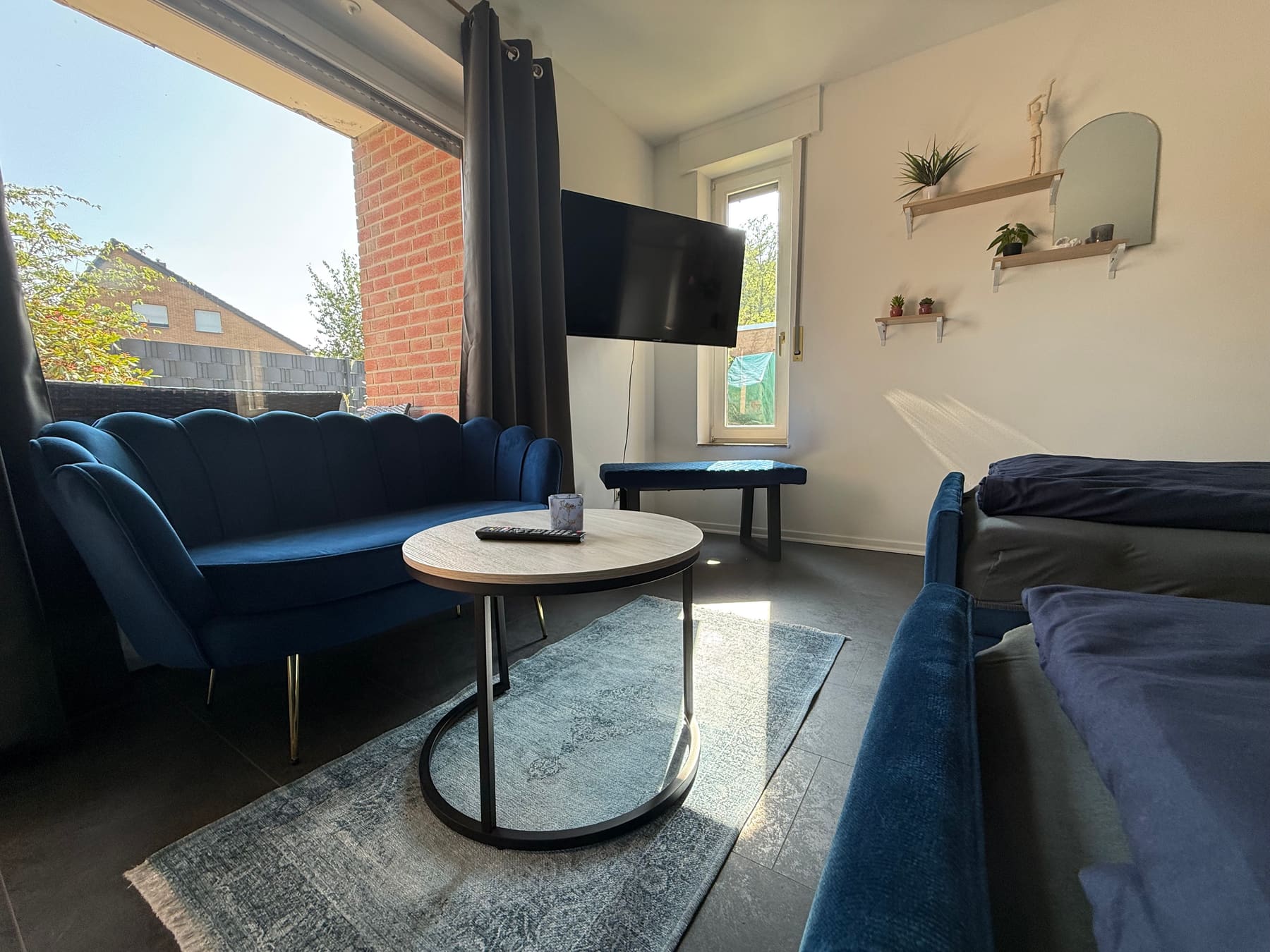 Sitzecke mit blauem Sofa und Smart-TV im Studio