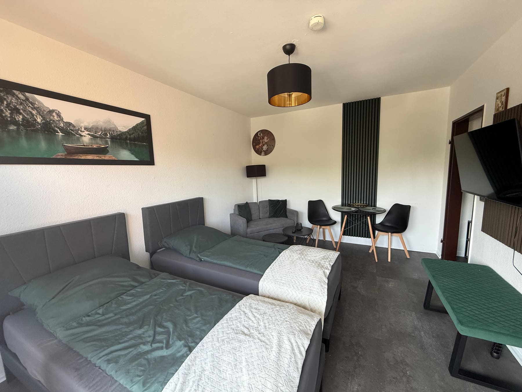Studio-Apartment mit Betten, Sofa und Esstisch
